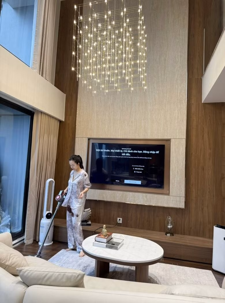 Tường gỗ kết hợp đá sáng màu phía sau ti vi sang trọng. Đèn Led dạng lưới thả từ trần cao tạo hiệu ứng thị giác độc đáo. Ảnh: FBNV