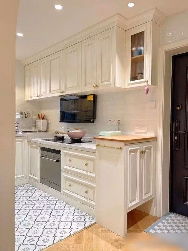 Tủ bếp sử dụng gam màu trắng đục ấm áp, kết hợp thiết bị màu đen sang trọng. Ảnh: Sohu