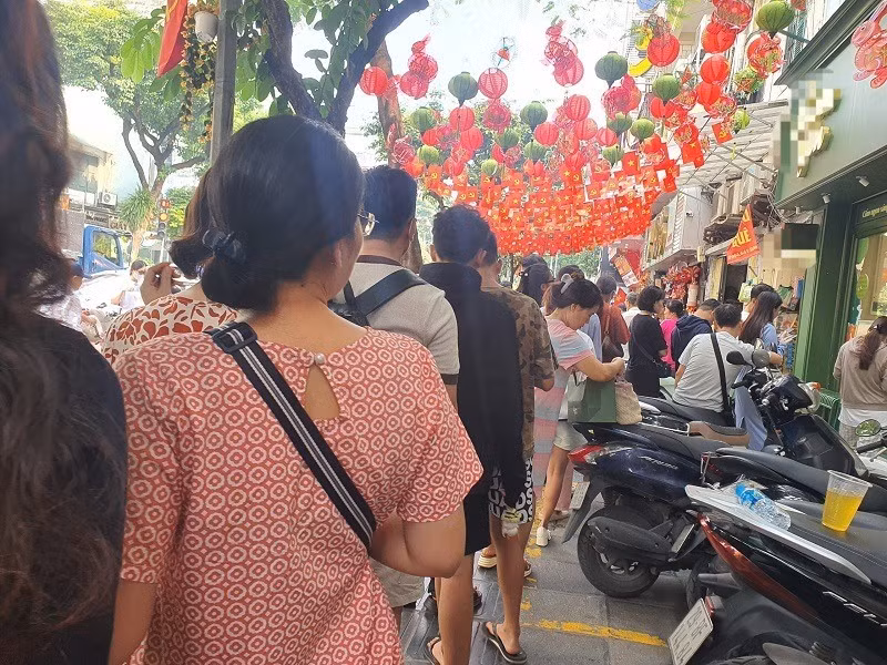 Muốn mua bánh nướng cốm xào đặc trưng của mùa thu Hà Nội, người dân phải xếp hàng. Ảnh: Arttimes