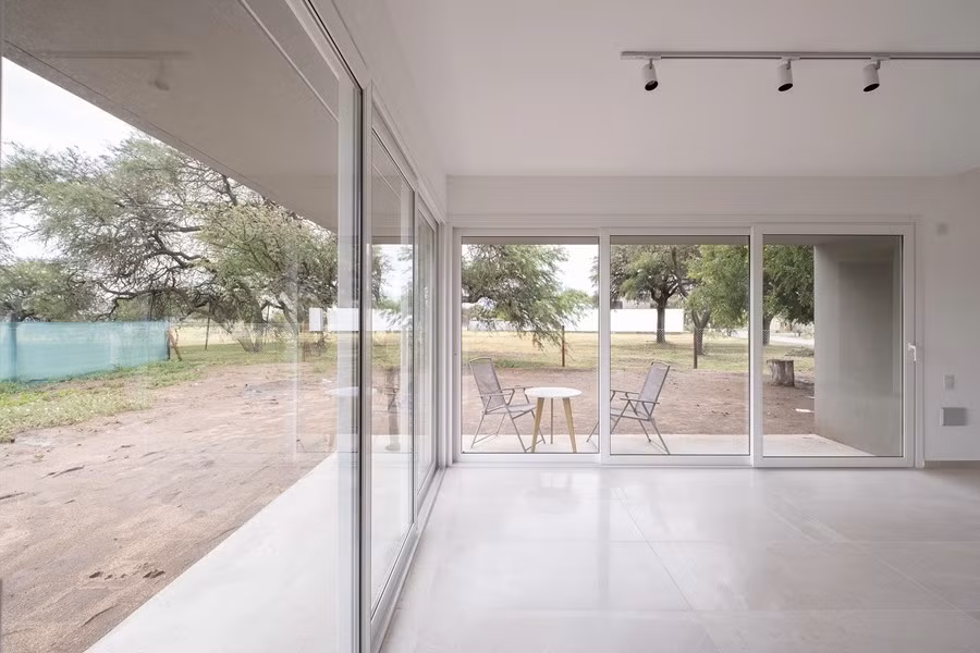 Không gian sinh hoạt kết nối trực tiếp với sân vườn thông qua hệ cửa kính trượt khổ lớn, giúp xóa ranh giới trong - ngoài. Ảnh: Amazingarchitecture