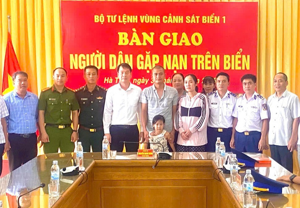 Lực lượng chức năng bàn giao hai bố con gặp nạn trên biển cho người thân.