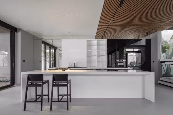 Khu bếp tối giản với hệ tủ giấu thiết bị, hút mùi và ổ cắm âm. Ảnh: Goku Agency