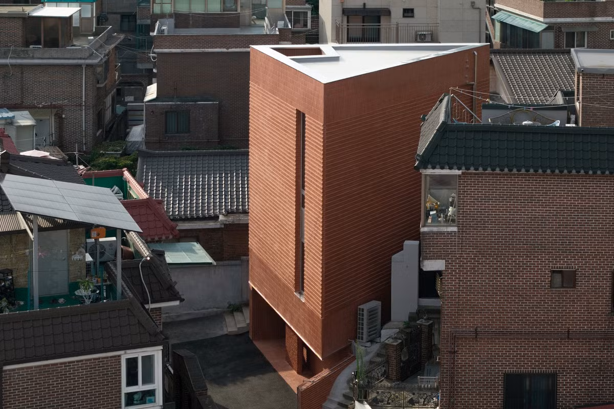 Hai bên là cầu thang ngoài trời cao dẫn lên khu đất lân cận phía trên, tạo thành một khu đất nằm sát đất cao hơn. Ảnh: Joel Moritz