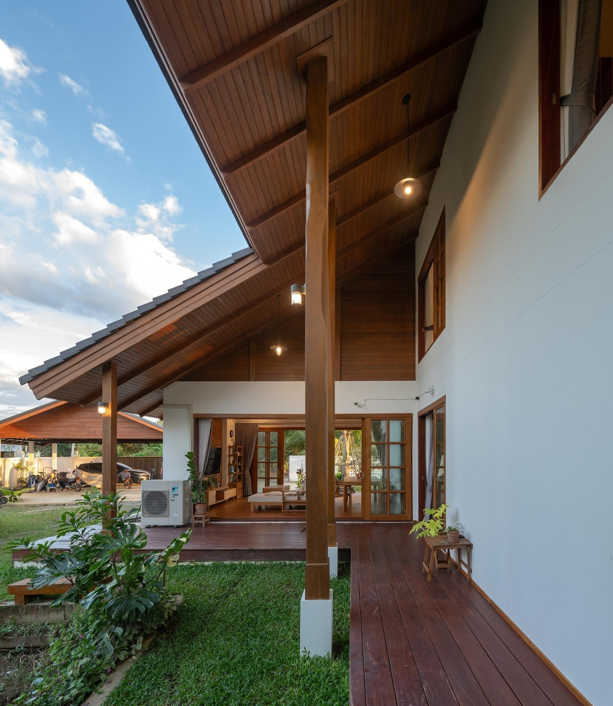 Cửa kính khung gỗ lớn mở rộng toàn bộ mặt tiền tầng trệt, góp phần giúp ranh giới giữa trong và ngoài gần như biến mất. Ảnh: Rungkit Charoenwat