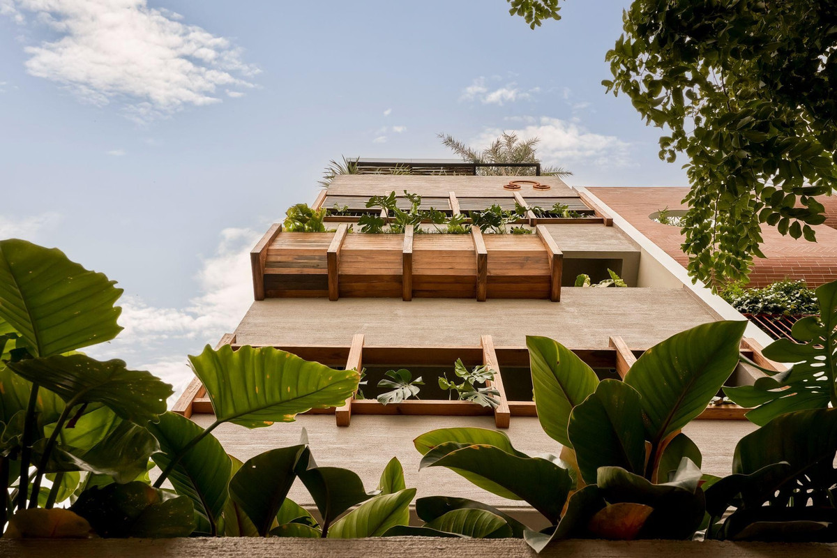 Mặt đứng của ngôi nhà được tạo thành từ nhiều lớp đặc - rỗng, gỗ biến tính, lam chớp, cây xanh...giống như một hệ sinh thái sống động treo lơ lửng giữa không trung. Ảnh: Phú Đào