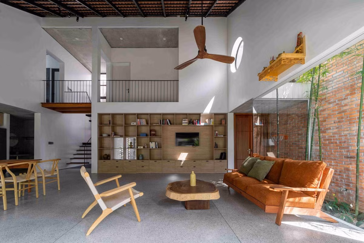 Phòng khách rộng thoáng nhờ thiết kế trần cao và kết nối với sân vườn. Ảnh: Hoàng Lê