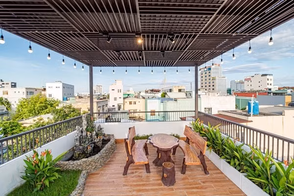 Sân thượng được bố trí thành khu vườn mini với cây cối và hòn non bộ. Ảnh: Phi House