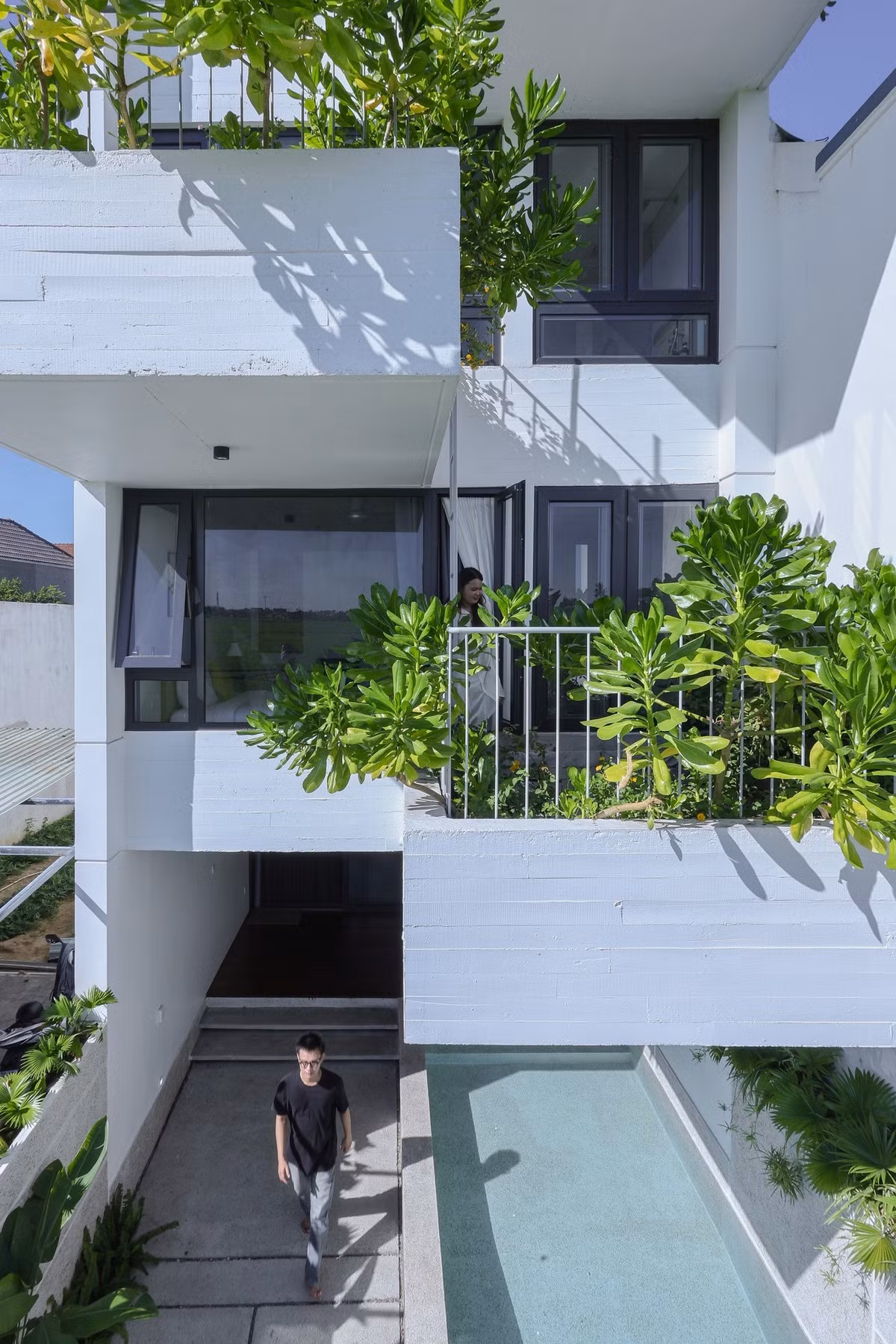 Ban công rộng trồng nhiều cây xanh, tạo thành một tấm rèm tự nhiên, vừa tạo điểm nhấn, lọc không khí vừa giúp che chắn bớt nắng gắt từ 9h sáng đến 3h chiều cho không gian bên trong. Ảnh: Sukha Studio.