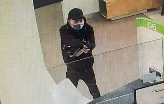 Hình ảnh Nam cầm súng chĩa vào nhân viên phòng giao dịch uy hiếp, yêu cầu giao nộp tiền.