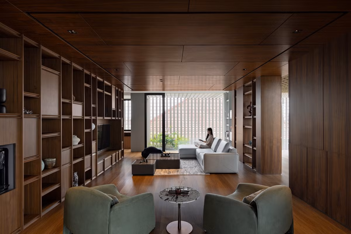 Trần phòng khách thấp giúp tạo cảm giác ấm cúng, nhưng khi bước đến khu vực thông tầng giữa phòng khách và bếp, trần nhà vươn lên gấp đôi chiều cao, tạo cảm giác mở rộng. Ảnh: Mario Wibowo