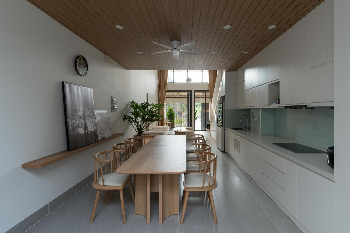 Ở tầng trệt, cầu thang và nhà bếp được bố trí dọc theo một bên, cho phép luồng không khí lưu thông từ sân trước ra phía sau. Ảnh: Quang Trần