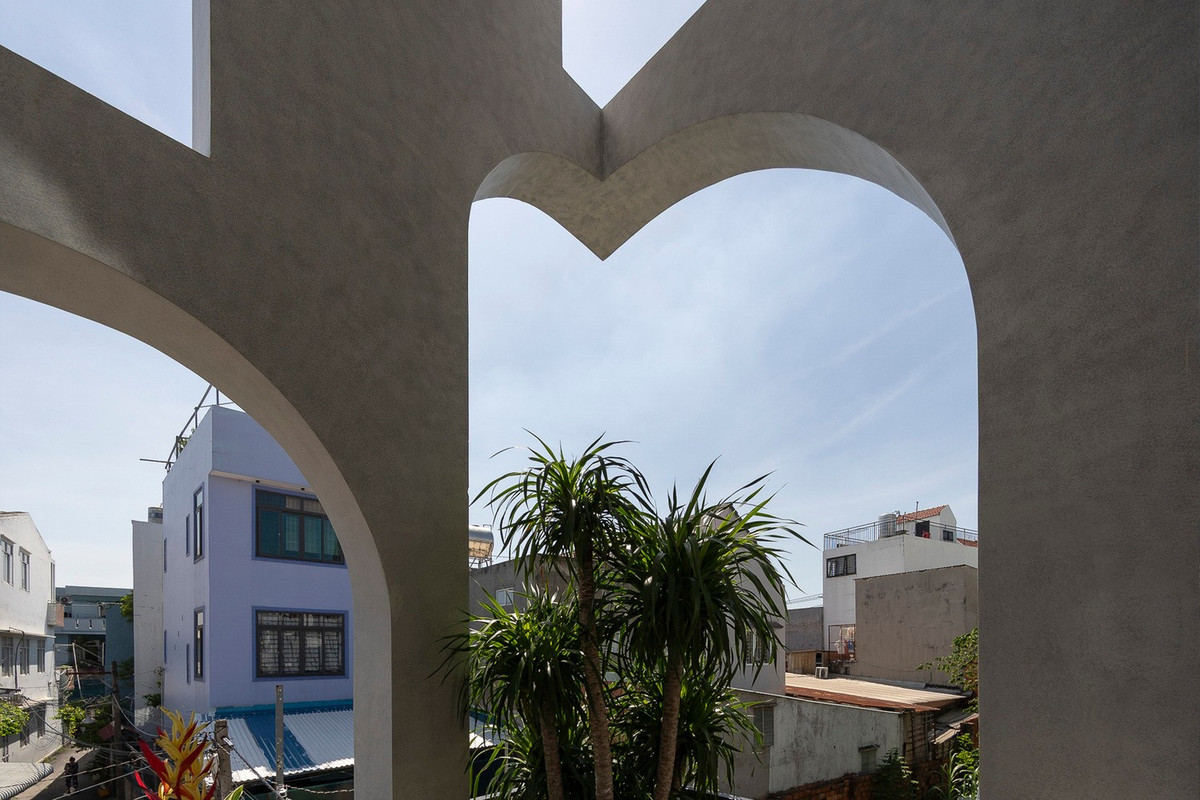 Thiết kế mặt tiền hai lớp với hệ vòm cách điệu không chỉ tạo điểm nhấn thẩm mỹ mà còn là lớp đệm khí giúp giảm nắng, đón gió và tăng cường sự riêng tư. Ảnh: Quang Trần