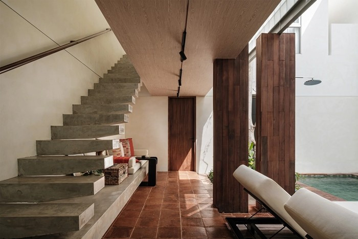 Giải pháp quan trọng nhất của căn nhà là đưa sân trong có hồ bơi vào giữa nhà. Thay vì dồn mọi không gian ra phía trước hoặc phía sau, kiến trúc sư đặt khoảng trống ở trung tâm, để ánh sáng, gió và cây xanh lan tỏa đều. Ảnh: Archdaily