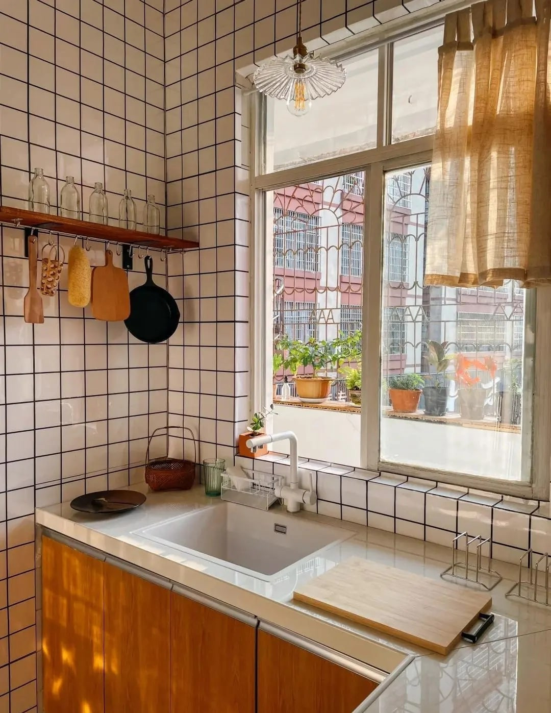 Khu bếp với tường ốp gạch trắng dạng vuông nhỏ, hệ tủ chữ L ôm sát tường giúp tối ưu diện tích. Ảnh: Toutiao