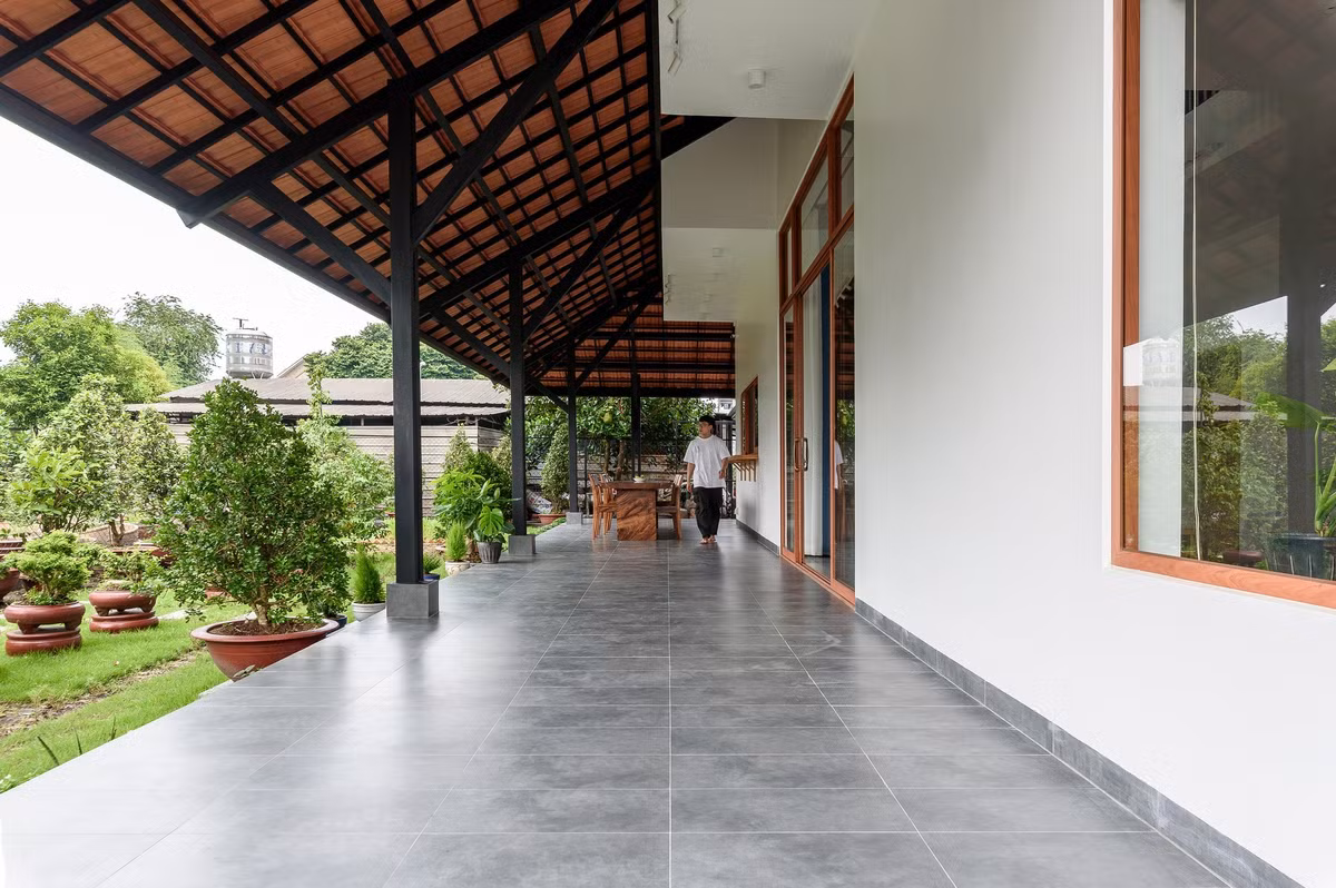 Khu vực sinh hoạt ngoài hiên bố trí bàn ghế, để gia chủ vừa làm việc, vừa giao lưu với hàng xóm. Ảnh: Lonton Studio