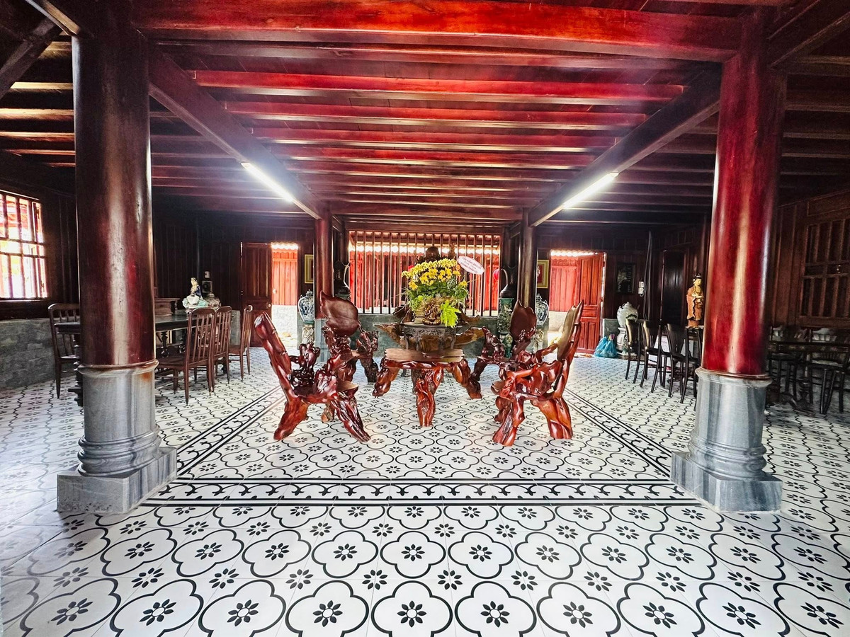 Bộ bàn ghế gỗ chạm khắc tinh xảo đặt trên nền gạch hoa cổ điển, toát lên vẻ sang trọng và hoài niệm. Ảnh: FB Hoàng Minh Bùi