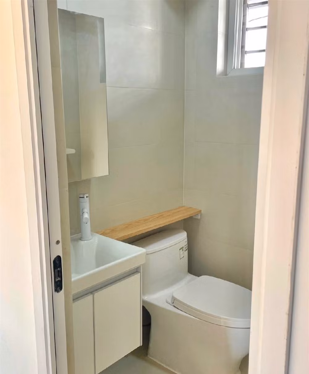 Phòng tắm chỉ 1,8m2 nhưng sạch sẽ, đủ dùng có lavabo, bồn cầu và vòi sen. Cửa kính mờ giúp lấy sáng đồng thời vẫn đảm bảo riêng tư. Ảnh: Sohu >>> Mời độc giả xem video: Căn hộ 25m2 - cơ hội cho nhiều người. Nguồn: VTV24