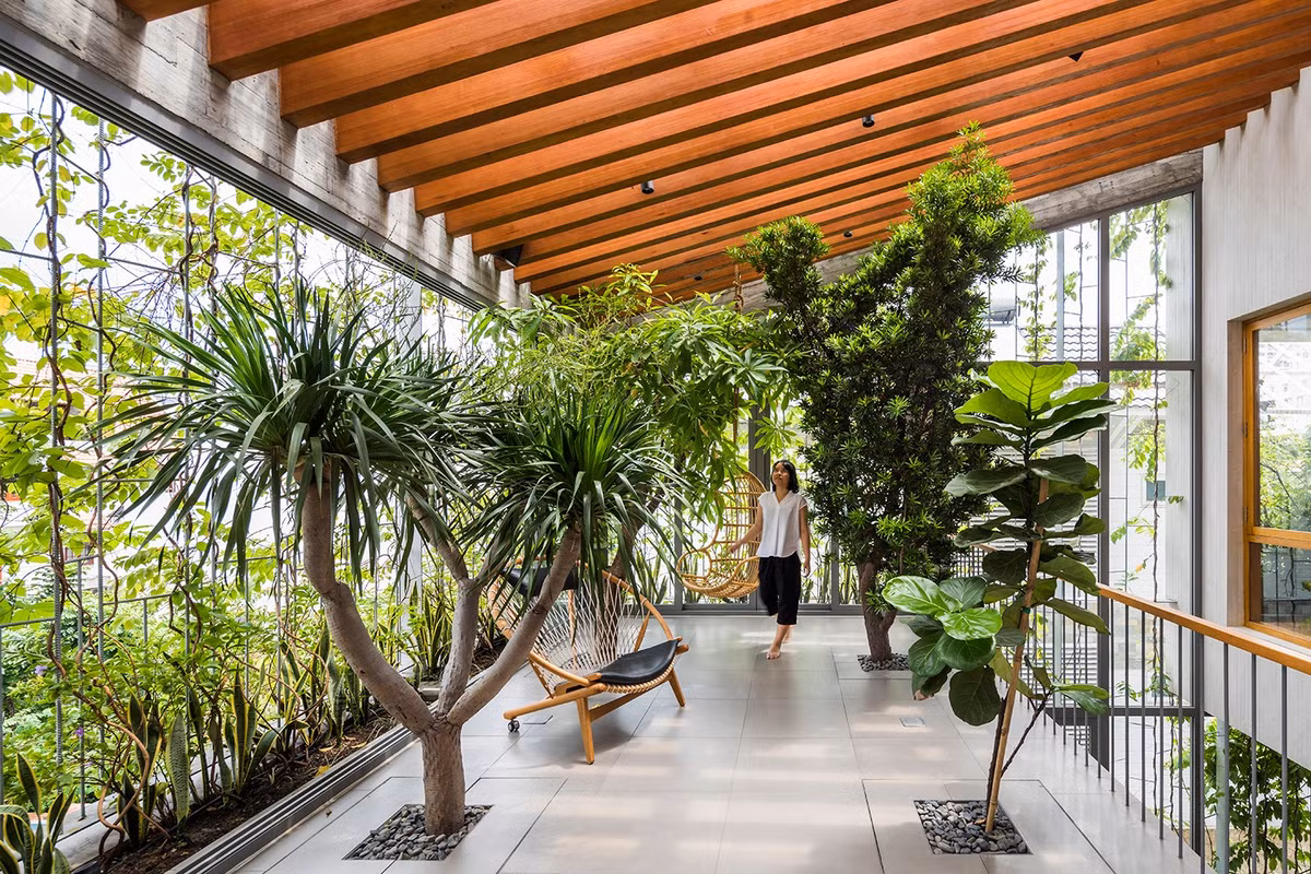 Trên tầng cao nhất, khoảng thông tầng đóng vai trò như một phòng gia đình với hàng cây xanh xung quanh. Ảnh: Hiroyuki Oki