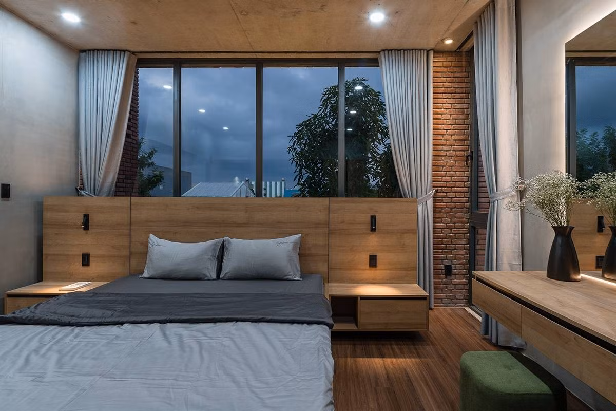 Phòng ngủ chính thiết kế đơn giản, sử dụng nội thất gỗ sẫm màu tạo cảm giác bình yên, thư giãn. Ảnh: Quang Trần