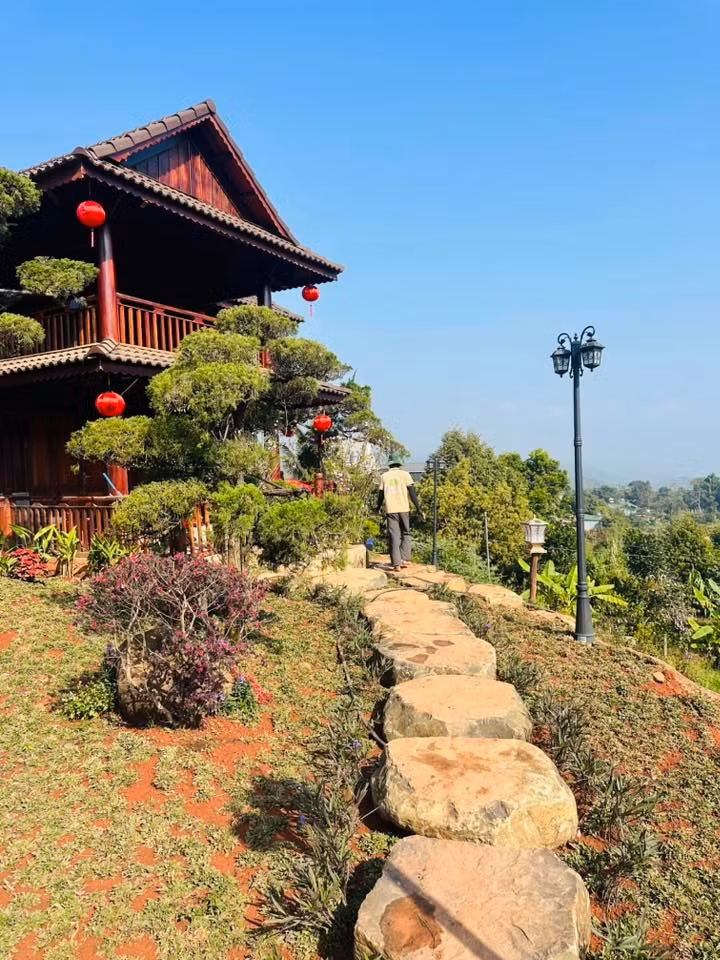 Khu nhà chính mang kiến trúc nhà sàn cách tân với hệ thống cột gỗ lớn, mái ngói trầm mặc, bậc thang bằng đá thô mộc...Ảnh: FBNV