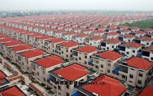 Đi xuyên qua cổng làng là một đại lộ với 818 biệt thự xếp thành hàng ngay ngắn hai bên. Ảnh: Jschina