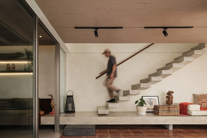 Cầu thang dẫn lên tầng trên đặt cạnh sân trong và hồ bơi, tạo trải nghiệm mới mẻ khi di chuyển. Ảnh: Archdaily