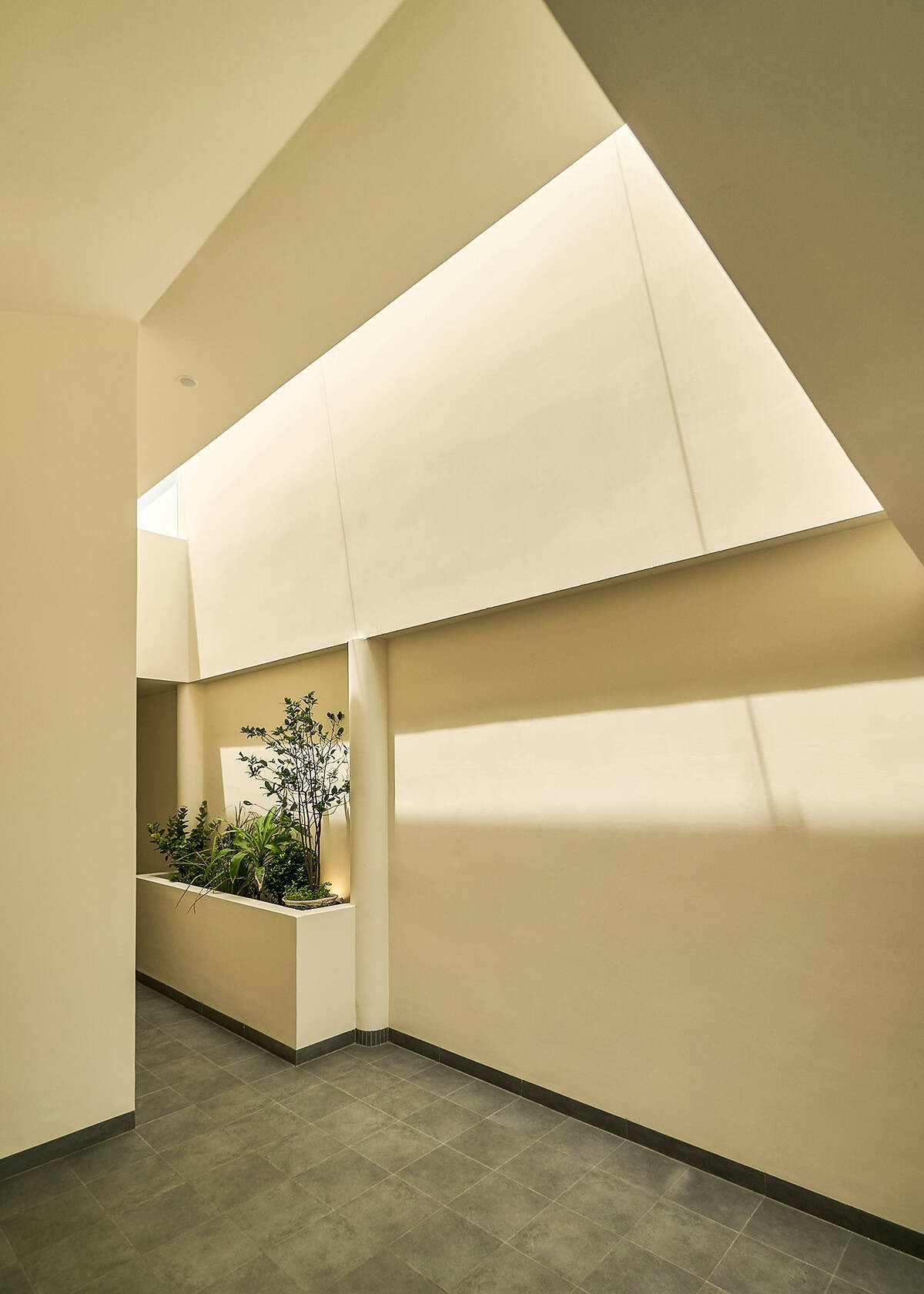 Vết cắt dài và hẹp trên mái giúp ánh sáng len lỏi qua ba mặt kính, phản chiếu và lan tỏa. Ảnh: Nam Võ