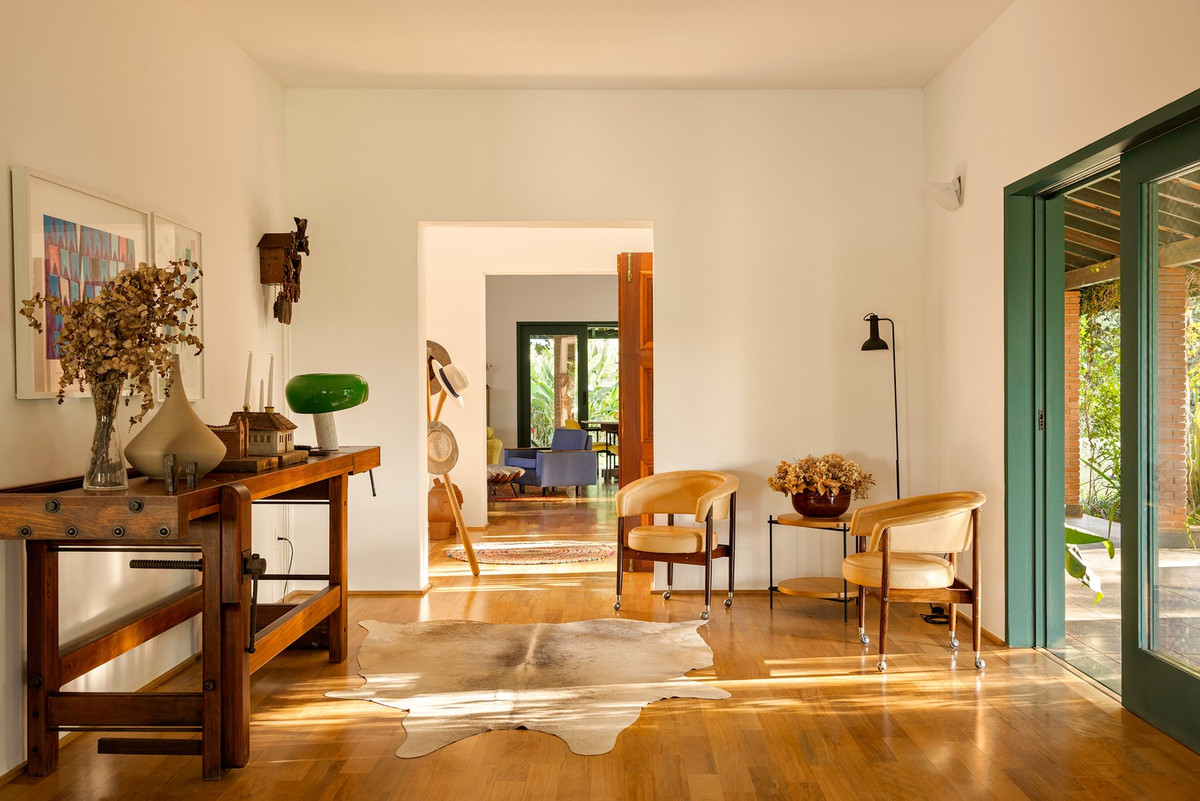 Không gian mở ra sân trong thông qua những cánh cửa kính và gỗ trượt rộng, xóa nhòa ranh giới giữa nội thất và khu vườn. Ảnh: Joana França