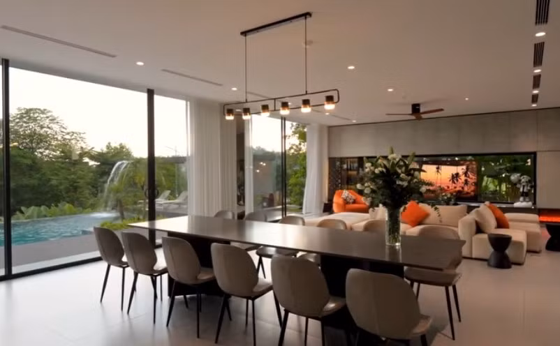 Bàn ăn rộng nhìn ra khu vực bể bơi bên ngoài. Ảnh chụp màn hình NhaF