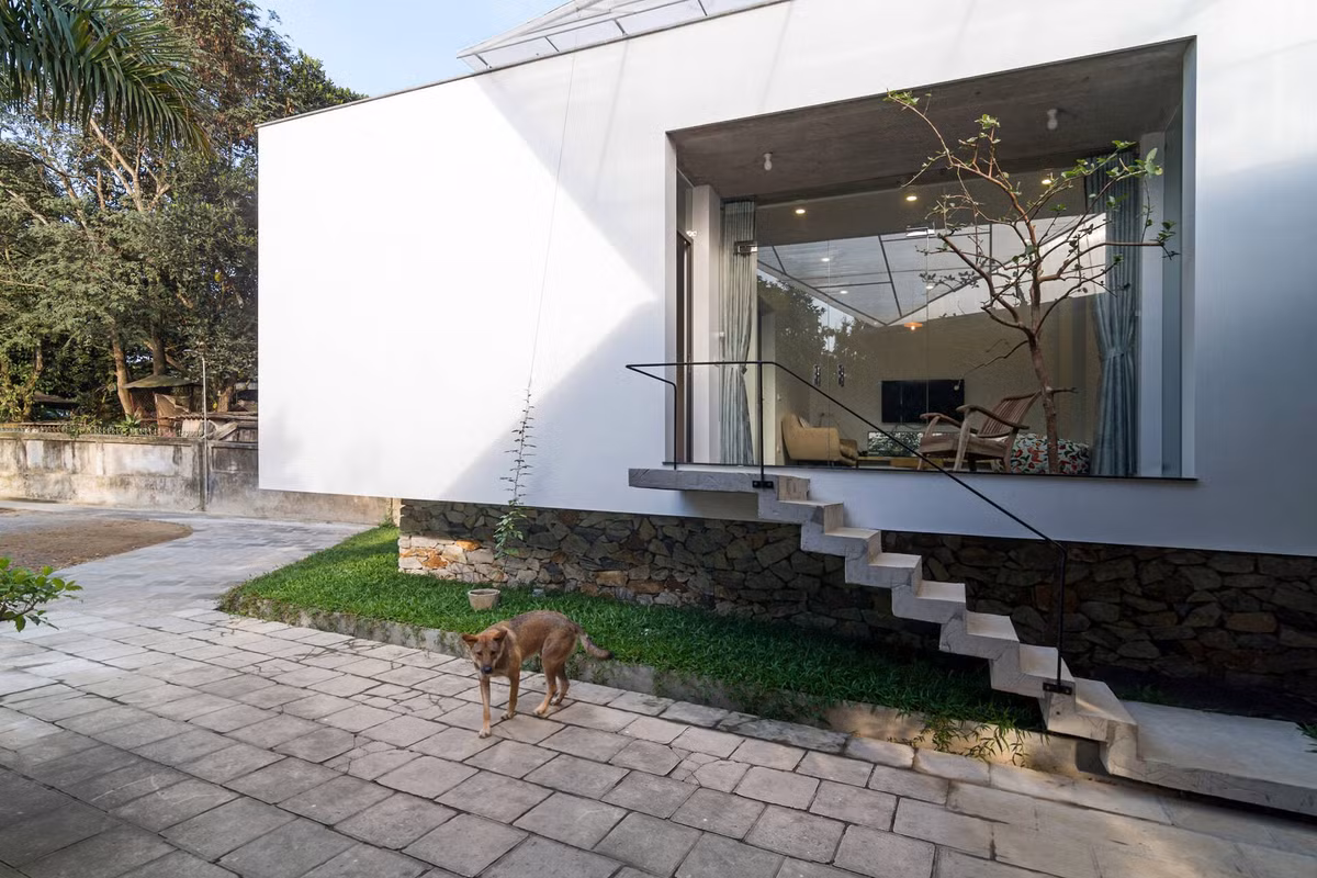 Bố cục ngôi nhà được tổ chức tối giản, với cầu thang nhỏ kết nối từ sân lên không gian sinh hoạt chính. Ảnh: Hoang Le &amp; NKPA
