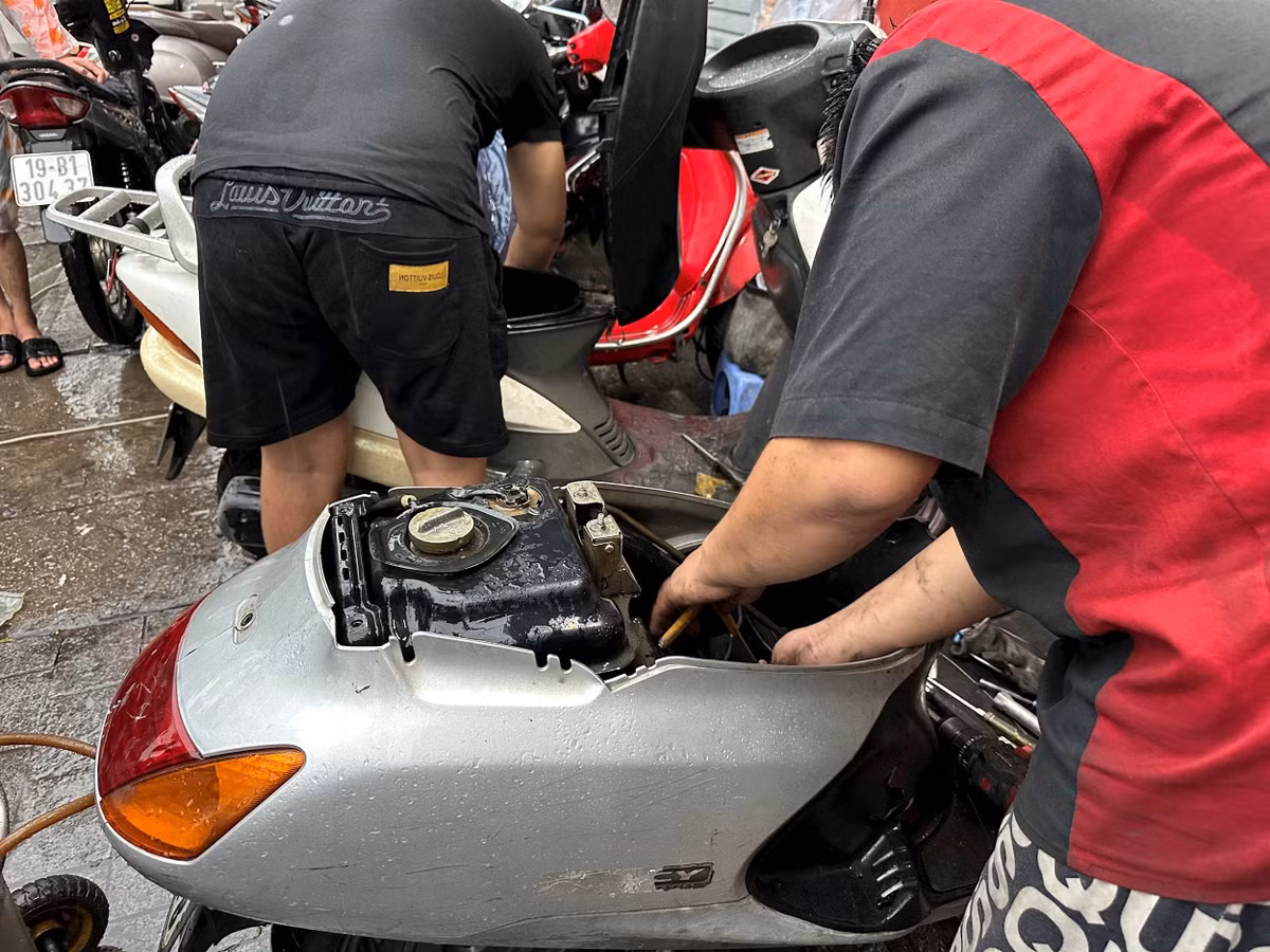 Theo một thợ sửa xe lâu năm ở phường Cầu Giấy (Hà Nội), mưa ngập là chúng tôi làm không kịp thở. Ảnh: Daibieunhandan