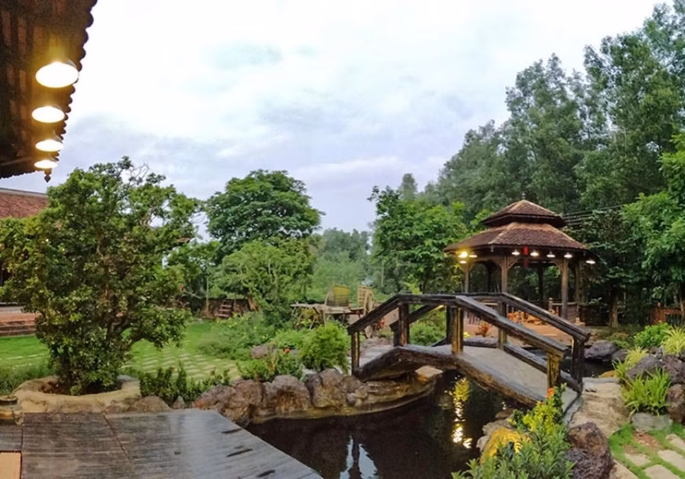 Căn biệt phủ có nhiều gian nhà liền kề, hai cổng chính và phụ. Lối đi giữa các gian nhà được trang trí bằng nhiều tiểu cảnh, cây xanh, giếng nước. Ảnh: FBNV