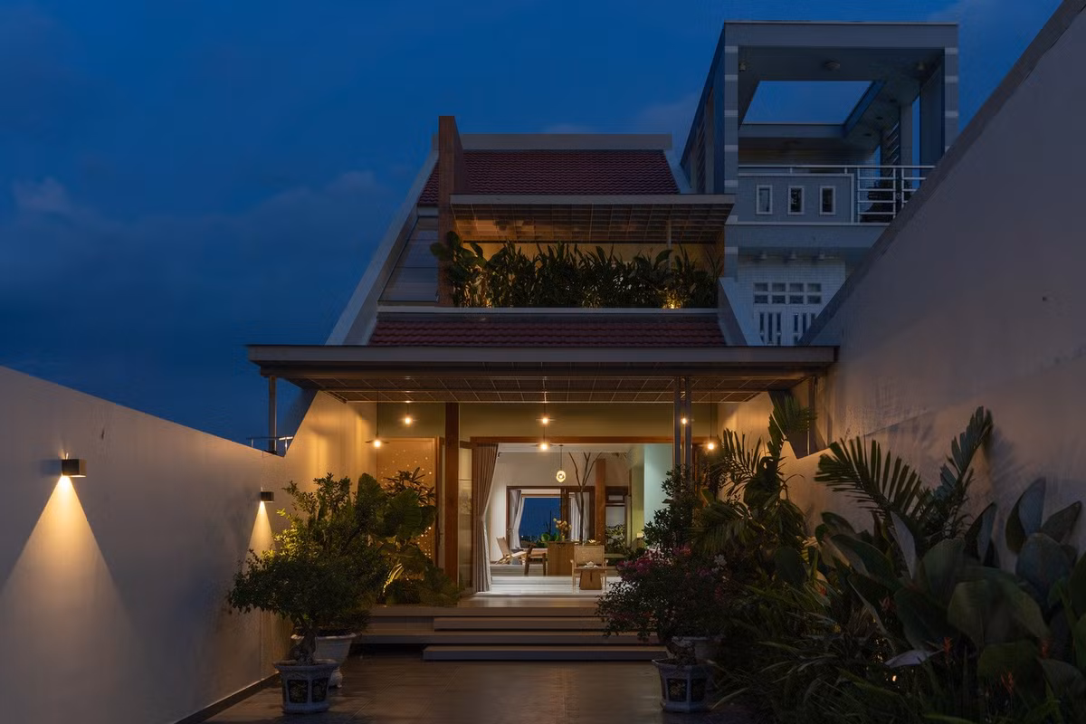 Khối nhà chính được lùi sâu vào trong khu đất, nhường khoảng sân rộng phía trước như một “vùng đệm xanh” giúp giảm tiếng ồn và lọc bụi. Ảnh: Quang Đạm