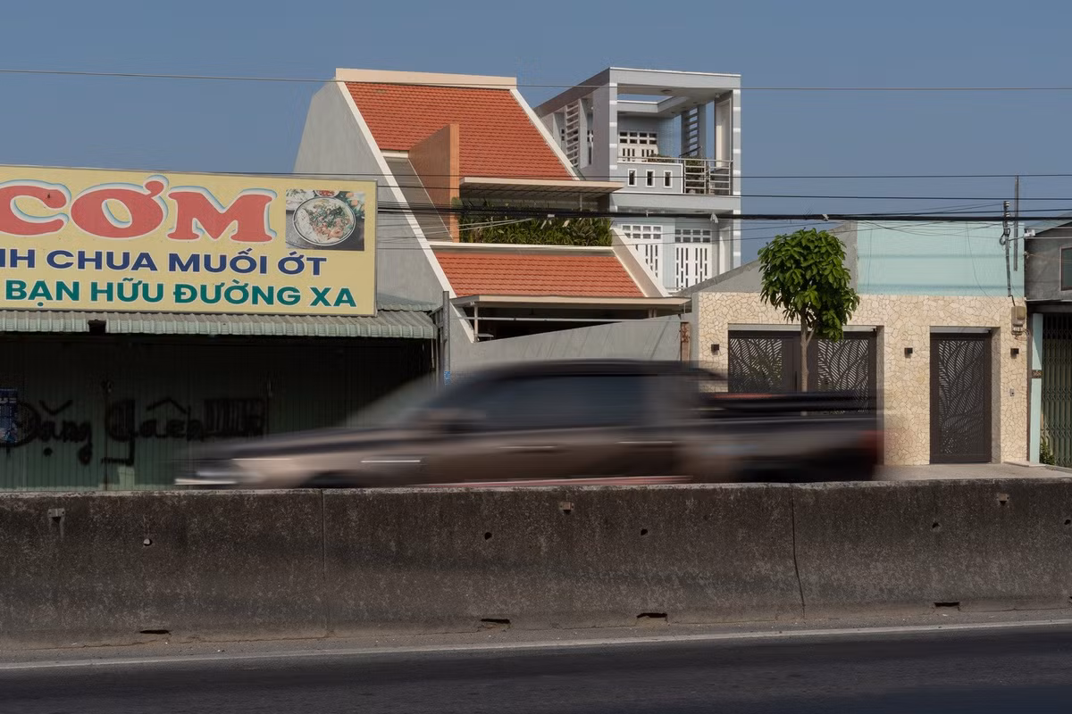 Nằm cạnh tuyến quốc lộ đông đúc tại Long An, ngôi nhà đối mặt với hai thách thức lớn: tiếng ồn xe cộ và bụi mịn từ giao thông. Ảnh: Quang Đạm