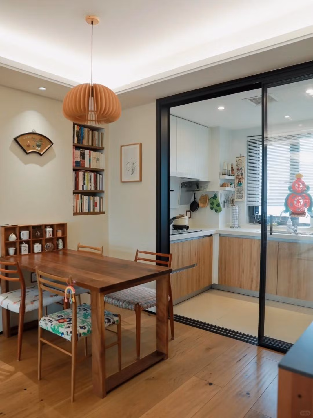 Phòng bếp gọn gàng với tủ chữ L ôm sát tường, kệ treo bên trên để xoong nồi, muỗng và chai gia vị. Ảnh: Toutiao