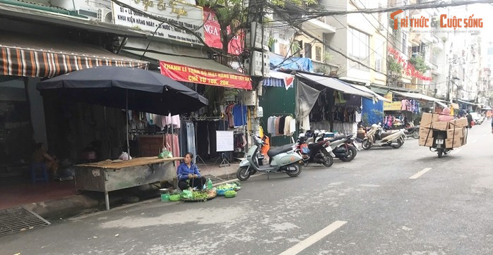 Một tiểu thương bán rau ngồi ngay xuống lòng đường.