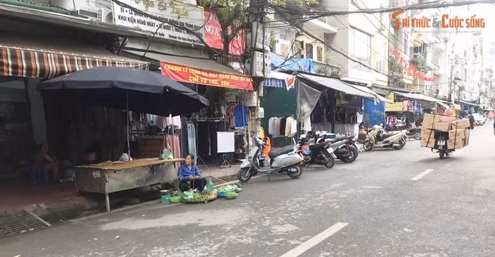 Một tiểu thương bán rau ngồi ngay xuống lòng đường.