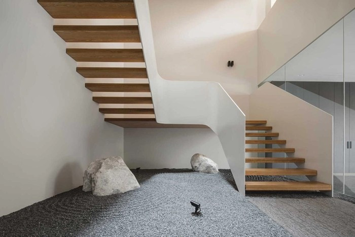 Ở tầng 1, cầu thang kết thúc tại một khoảng sân nhỏ rải sỏi, mang lại cảm giác tĩnh. Ảnh: Archello