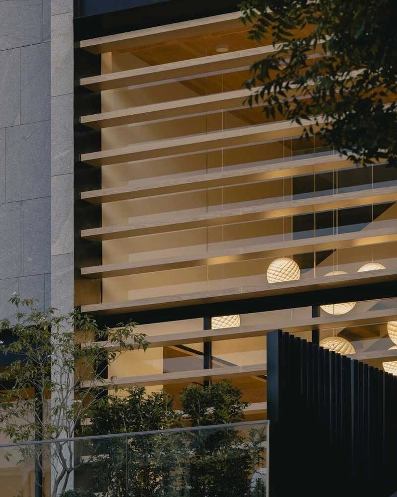 Mặt tiền sử dụng các thanh dầm ngang chạy đều trước mảng kính lớn, giúp điều tiết ánh sáng theo thời điểm trong ngày. Ảnh: Archello