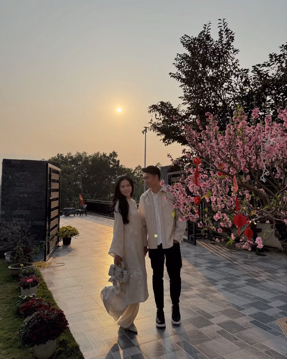 Dịp Tết năm ngoái, cặp đôi chụp ảnh với bối cảnh căn biệt thự gia đình được trang hoàng với cây đào rực rỡ. Ảnh: FBNV