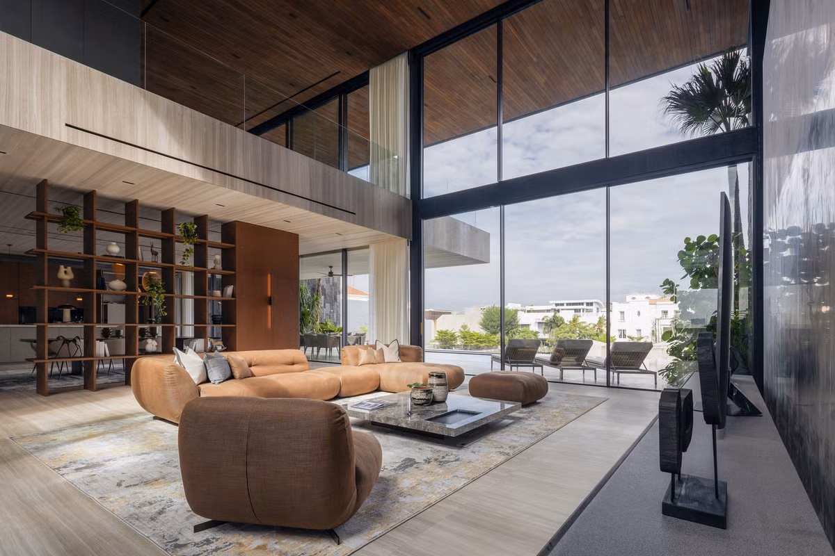 Phòng khách lớn nằm dưới khoảng thông tầng, nhìn thẳng ra khu bể bơi. Ảnh: Indra Wiras