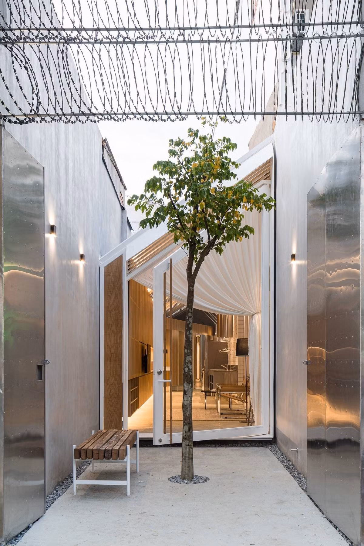 Khu đất có mặt tiền tiếp xúc trực tiếp với trục đường chính. Với chều dài đặc biệt, kiến trúc sư chọn giải quyết theo phương pháp phân lớp trong bố cục công năng, nhằm phân lớp không gian và giảm thiểu tiếng ồn triệt để từ bên ngoài. Ảnh: Quang Trần