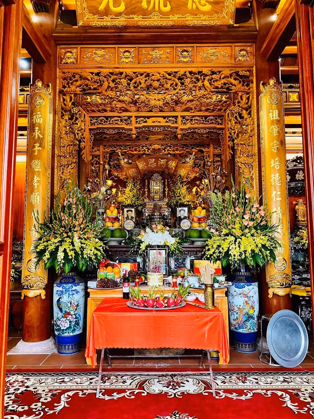 Ngôi nhà gỗ 5 gian gợi lên nét bình dị, 3 gian giữa thiết kế mở. Gian chính giữa là nơi thờ tự với án gian, cửa võng thờ, hoành phi câu đối được thếp vàng 24k. Ảnh: Happynest