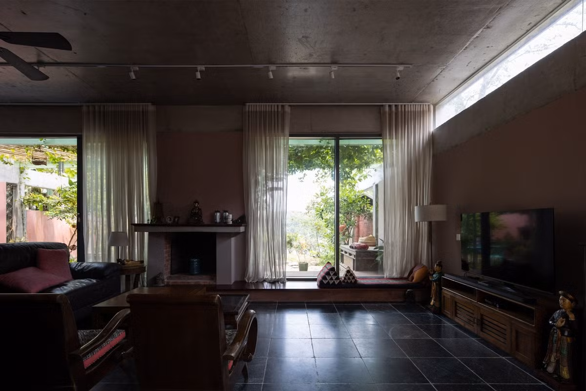 Phòng khách thoáng mát có view hướng ra khoảng sân cùng màu xanh cây cối. Ảnh: Chimnon studio