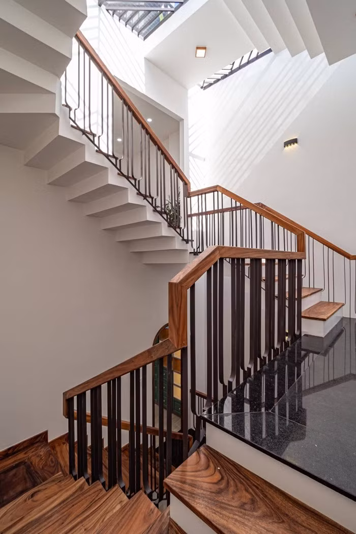 Cầu thang gỗ chắc chắn dẫn lên các tầng của ngôi nhà. Ảnh: Phi House