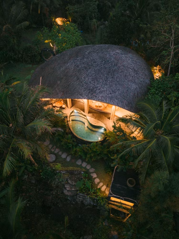 Hệ mái được nâng đỡ bằng các cụm cột tre cao, giúp mở rộng tầm nhìn ra không gian tự nhiên và cố định công trình trên địa hình dốc. Ảnh: Archdaily