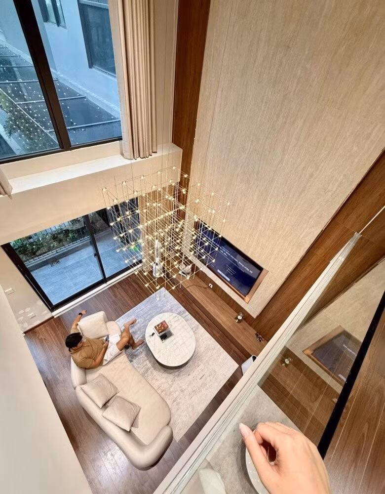 Ngôi nhà mới gây ấn tượng với phong cách sống hiện đại, tối giản. Trần cao cùng đèn thả ánh vàng tạo điểm nhấn. Ảnh: FBNV