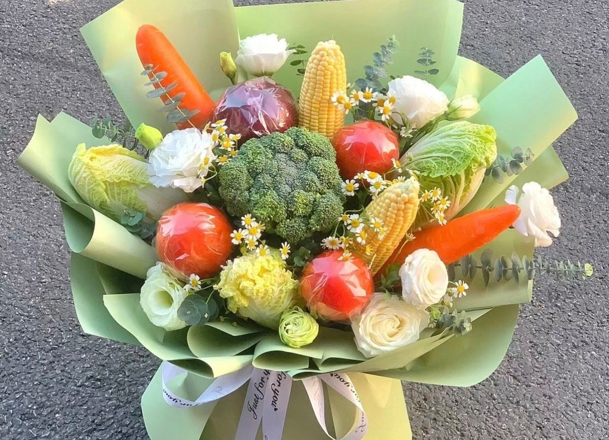 Thay vì hoa tươi, nhiều người chọn bó hoa từ rau củ, trái cây, hoặc đồ ăn vặt vừa ngộ nghĩnh, vừa thực tế. Ảnh: Facebook