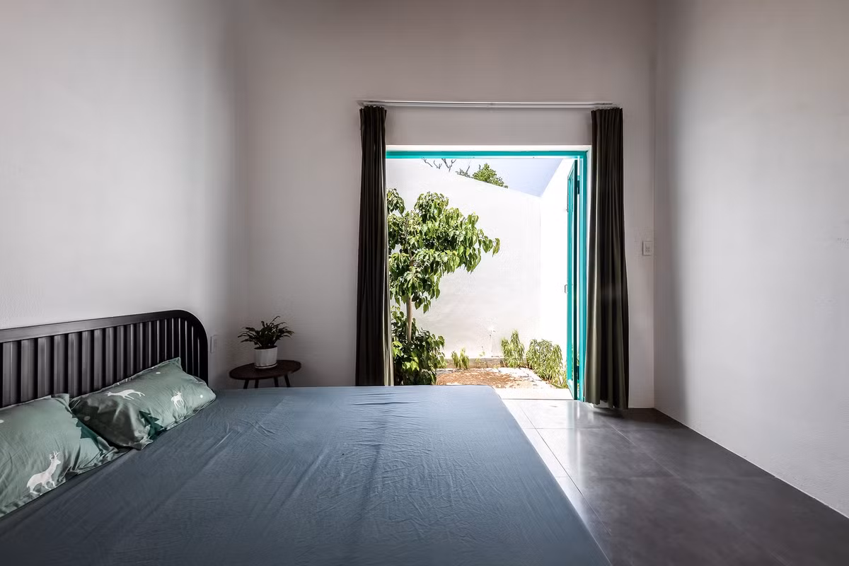 Nhà gồm 2 phòng ngủ riêng biệt và tách rời bởi khoảng sân vườn. Thiết kế này đem lại sự riêng tư cần thiết đồng thời đảm bảo mỗi không gian đều nhận được nhiều ánh sáng và không khí trong lành từ cây cối. Ảnh: Minq Bui
