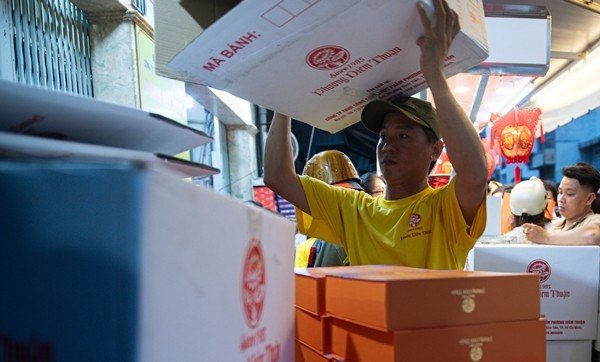 Khoảng 15 đến 20 phút, nhân viên lại đẩy thêm các thùng hàng mới. Bên trong, hơn 20 nhân viên liên tục nhận đơn, tính tiền và đóng hộp, gần như không ngơi tay. Ảnh: Vietnamnet